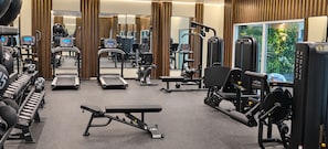 A gym with treadmills, weight machines, and exercise balls.