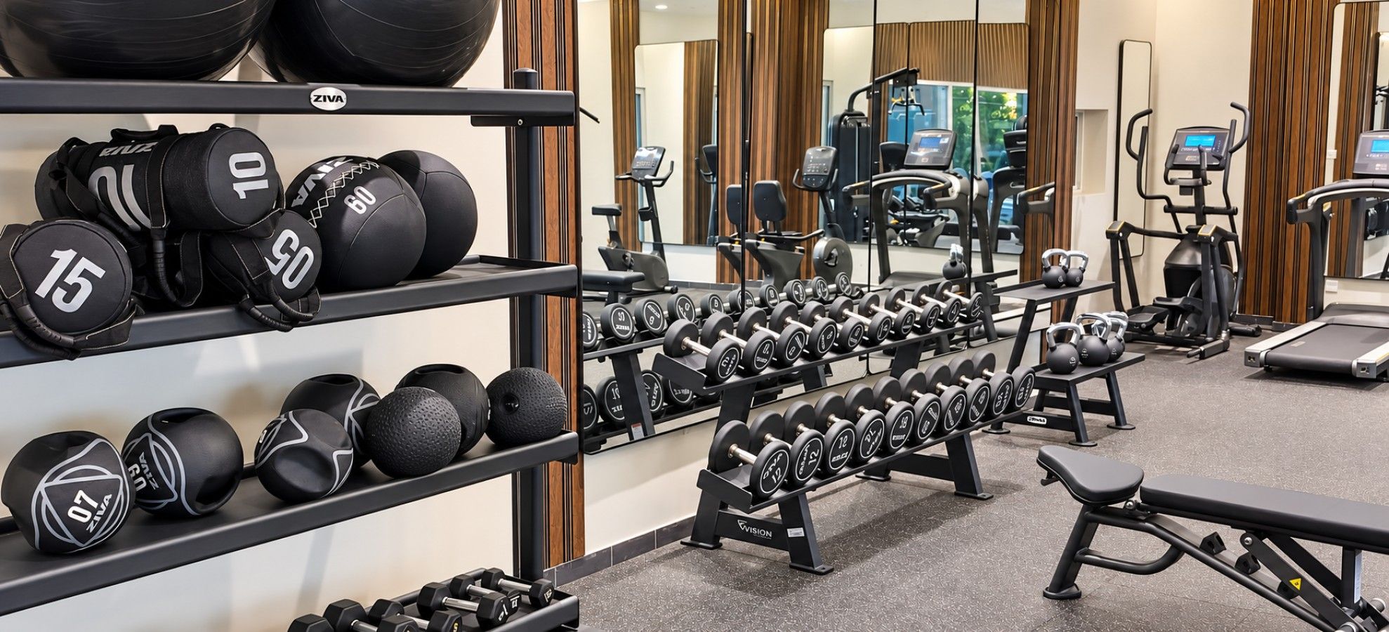 A gym with various exercise equipment including dumbbells, medicine balls, and treadmills.