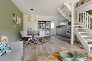 A modern interior with a dining area, kitchen, and staircase. - Holiday home in Den Helder with barbecue (Den Helder)
