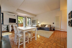 A modern living room with a dining area, a sofa, and a TV. - Vatican Luxury Apt with Garden (Roma)