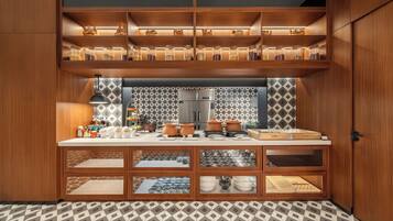 A modern kitchen with wooden cabinetry, a central island, and a patterned backsplash.