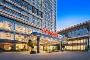 Un hotel moderno con un llamativo letrero que dice 'Intercity Hotel'.