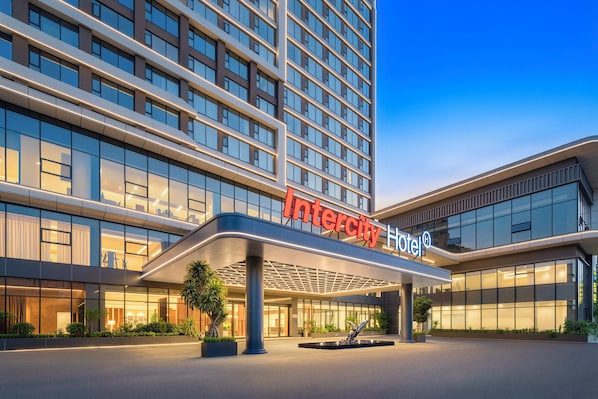 Un hotel moderno con un llamativo letrero que dice 'Intercity Hotel'.