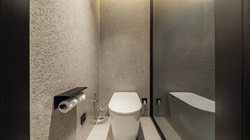 A modern bathroom with a toilet, a shower area, and a towel rack.