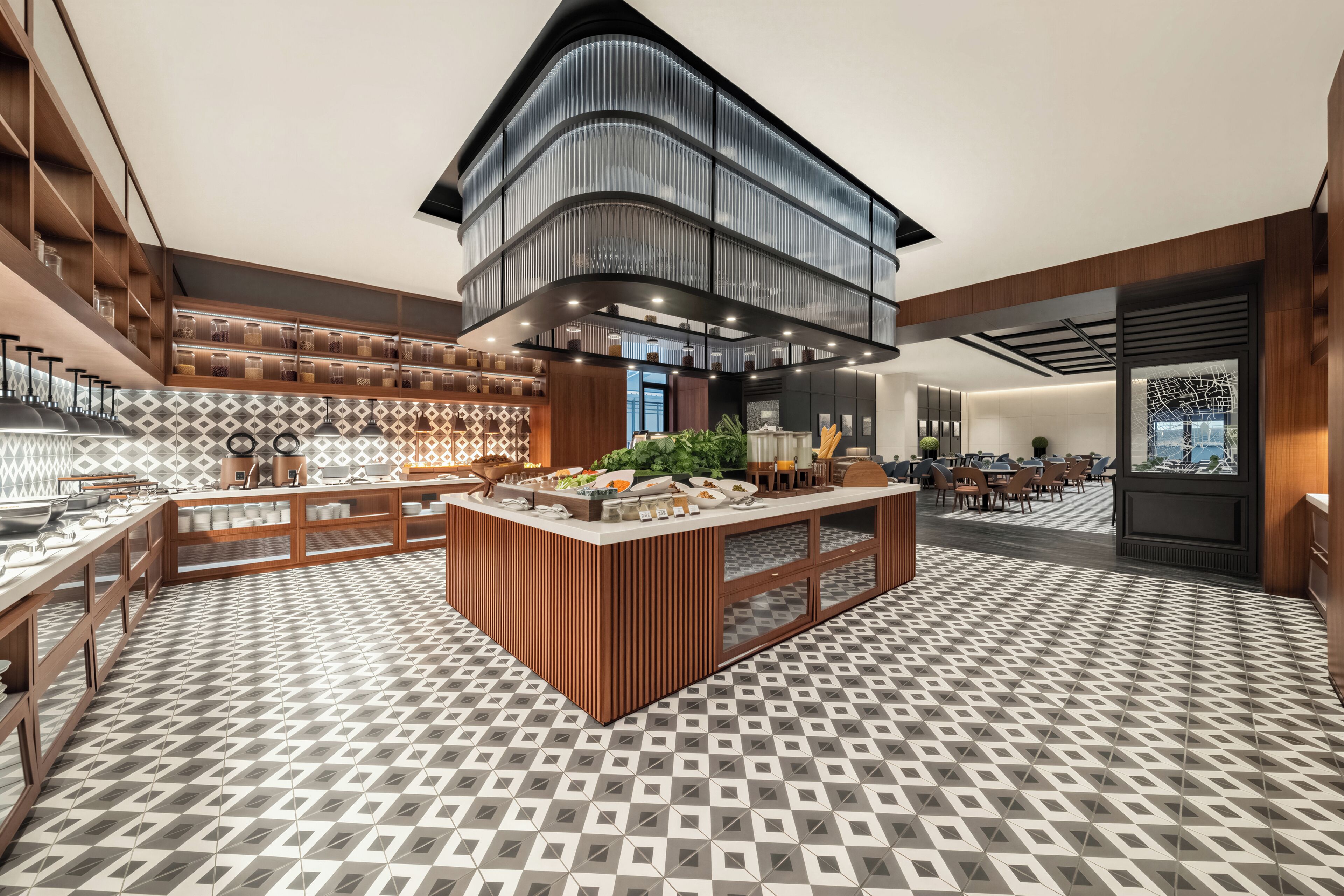 A modern hotel lobby with a central island, wooden paneling, and a patterned floor.