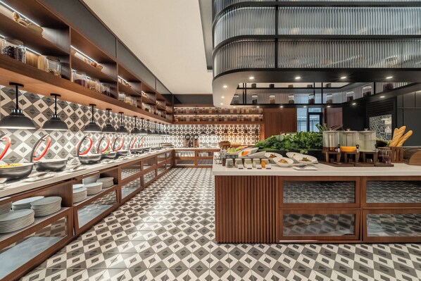 Una cocina moderna con una disposición tipo bufé, estantes de madera y baldosas de suelo estampadas.