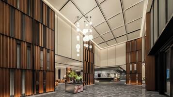 A spacious lobby with a reception desk, seating area, and a modern ceiling design.