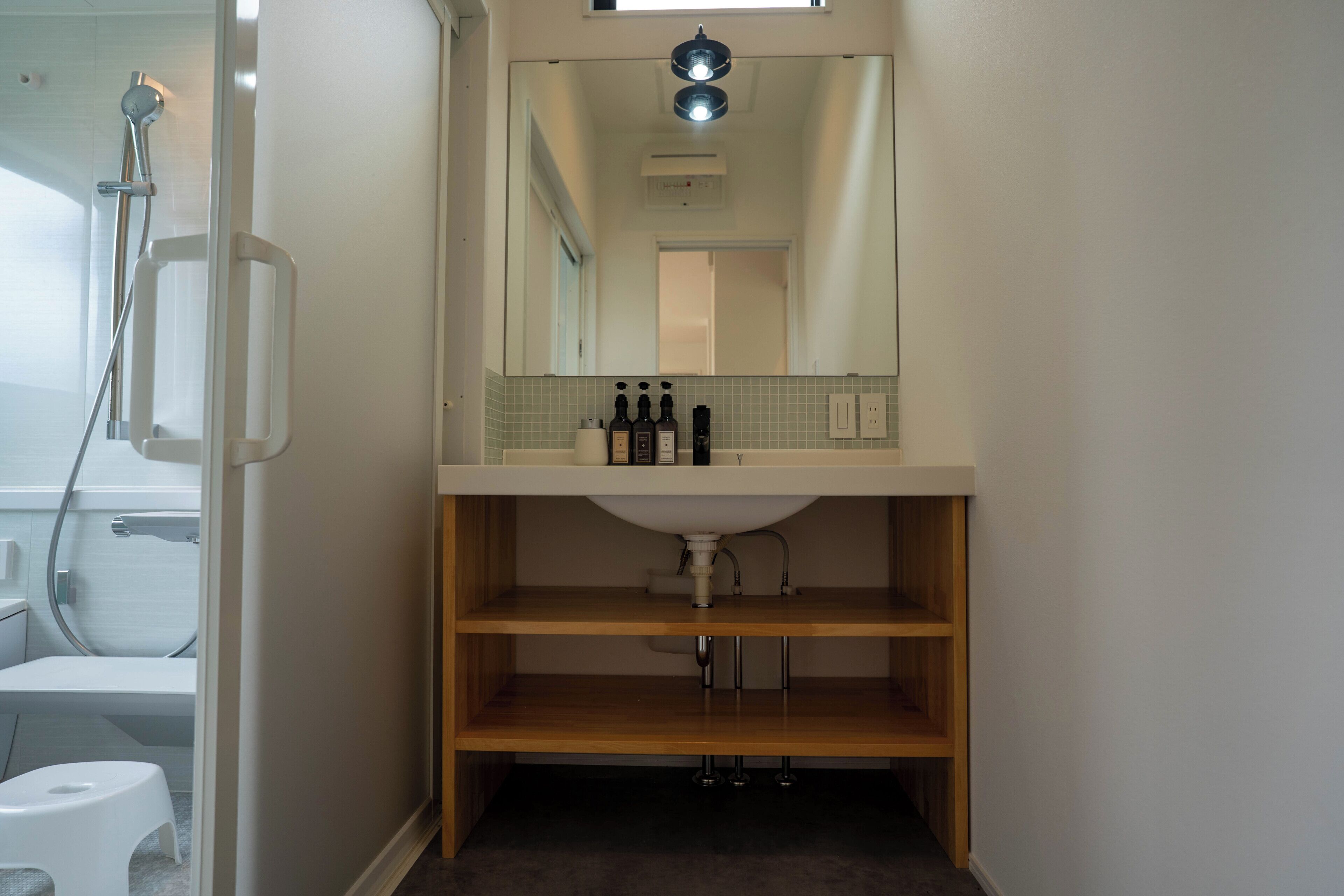 A bathroom with a shower, toilet, and sink area.