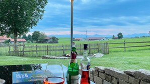 Une table avec un jeu de société, un verre à vin et deux bouteilles de vin.
