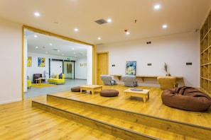 A modern interior with a wooden floor, seating area with bean bags, and a visible 'hell' sign on the wall. - Xi'an Inner Guest House (Xi'an)