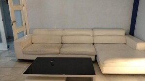En beige hörnsoffa med ett svart soffbord framför.