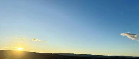 A rural landscape with rolling hills and a clear sky.