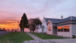 Una propiedad residencial con entrada para coches, césped y un gran árbol.