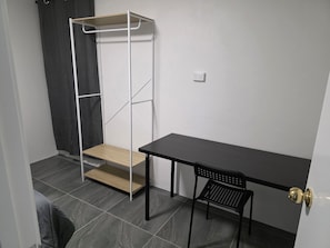 A compact room with a bed, a small table, a chair, and a wardrobe with a step ladder. - Sansa Farmhouse (Kelmscott)