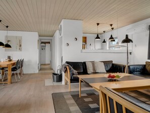 Ein stilvolles Wohnzimmer mit Essbereich, einer Couch und einer Küchenzeile.