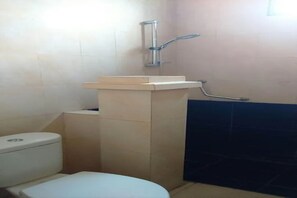 A bathroom with a toilet, a pedestal sink, and a shower.