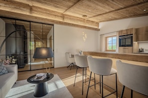 Una cocina moderna con armarios de madera, horno integrado y un amplio ventanal.