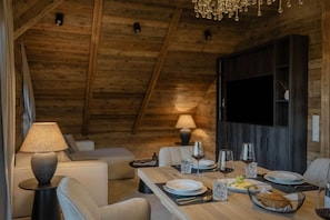 En mysig matplats med ett träbord dukat för två personer, en soffa och en lampa.