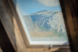 Ein Dachfenster mit Blick auf eine Berglandschaft.