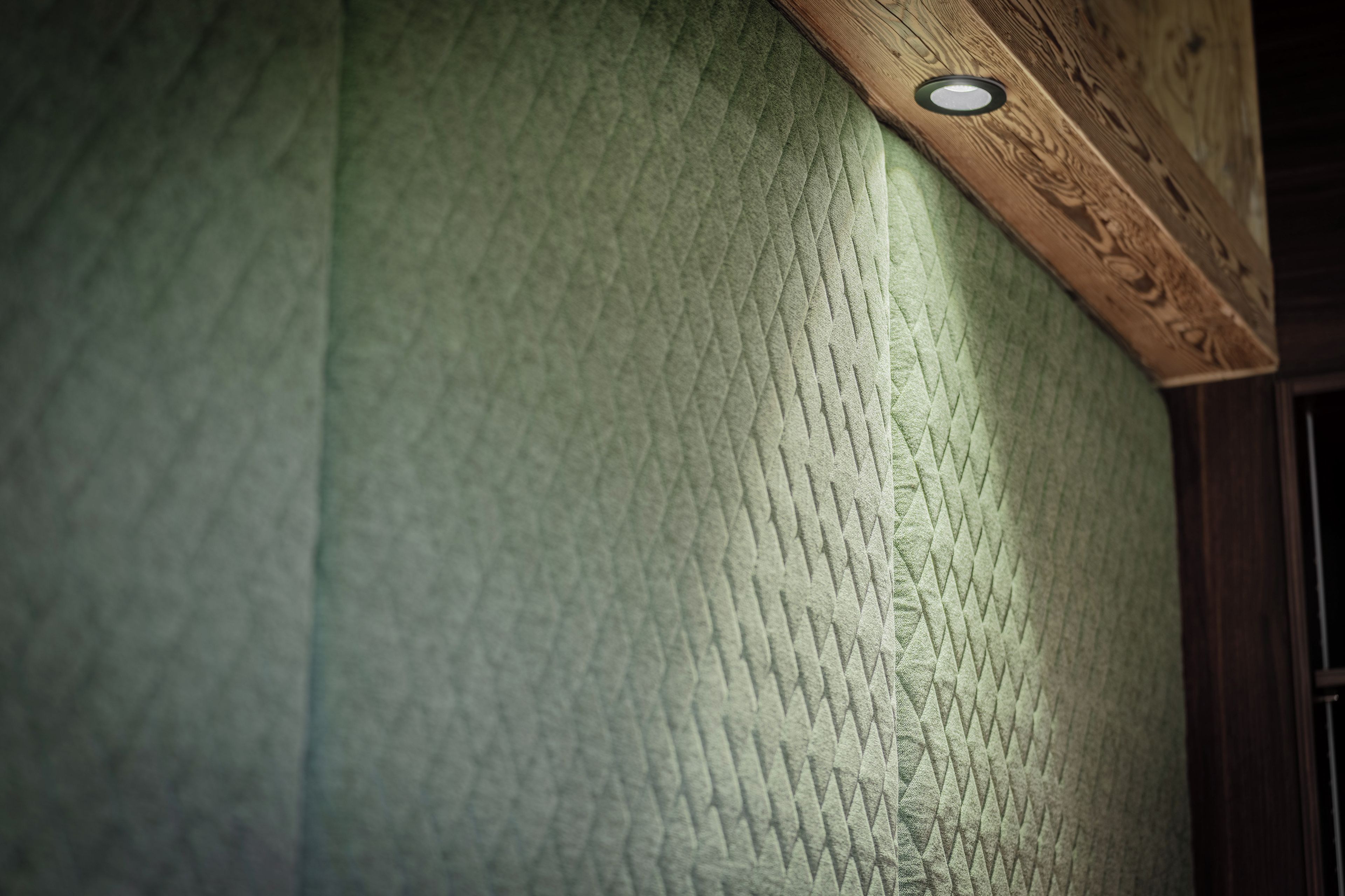 A textured wall with a recessed ceiling light.