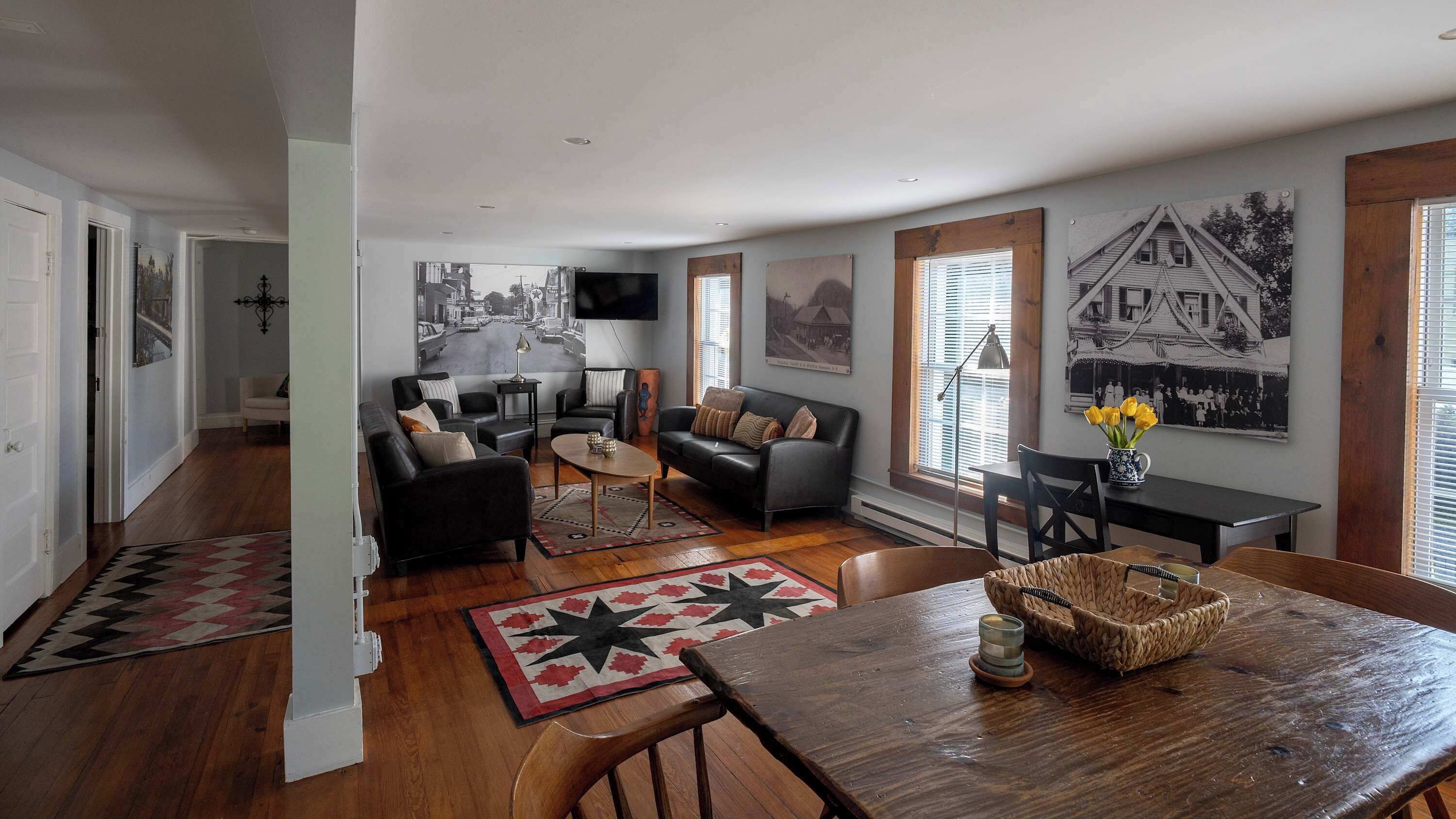 A living room with a fireplace, a dining area with a wooden table, and a hallway with a door.