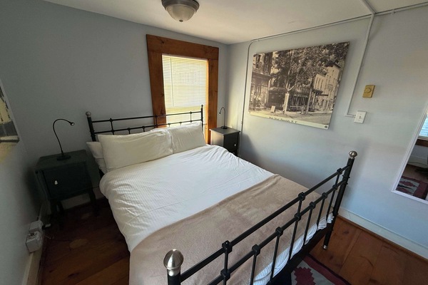 Queen bedroom with iron bed frame and village views