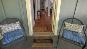 A hallway leading to a living area with a sofa and a dining table. - Historic Main St. Rosendale Apt (Rosendale)