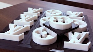 A living room with a sofa, a coffee table with 3D printed objects, a staircase, and a door in the background. - Fantastic 3-bedroom house with AC in charming Camden (Camden)