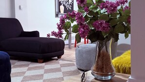 A living room with a sofa, a coffee table with a vase of flowers, a framed picture on the wall, and a sign that says 'Gather Together'. - Fantastic 3-bedroom house with AC in charming Camden (Camden)