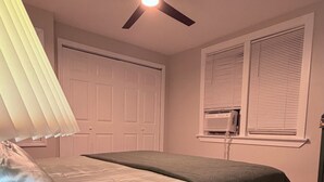 A bedroom with a bed, a ceiling fan, a window with blinds, and a door. - Fantastic 3-bedroom house with AC in charming Camden (Camden)