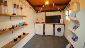 Une petite buanderie avec des étagères remplies de produits de toilette, un lave-linge et un sèche-linge.