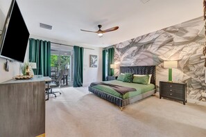 Your spacious bedroom invites rest with a dramatic accent wall, plush bedding in soothing greens, and a peaceful view of the outdoors through the sliding doors. - Reunion Resort: 8-Bed Villa, Arcade, Theater, Pool (Kissimmee)