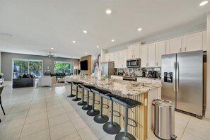 Your gourmet kitchen awaits with gleaming granite countertops, modern appliances, and a spacious island perfect for morning coffee or gathering with friends. - Reunion Resort: 8-Bed Villa, Arcade, Theater, Pool (Kissimmee)