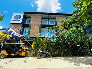 Un edificio con un cartel que dice 'Tandikan Suites Bed and Breakfast' y una motocicleta estacionada frente.