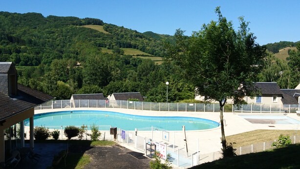 Ein Schwimmbad mit Blick auf grüne Hügel im Hintergrund.