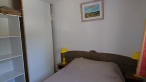 A bedroom with a bed, two bedside lamps, a wardrobe, and a framed picture on the wall. - Apartment between Aubrac and the Lot Valley (Saint Geniez d'Olt et d'Aubrac)