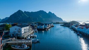 A coastal town with a marina, buildings, and a mountain in the background.