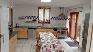 Ett kompakt kök med ett matbord, en spis och en diskmaskin.