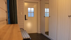 A hallway with a wooden bench, a door with a window, and a wardrobe. - Arctic Comfort 2, Tromsø (Tromsø)