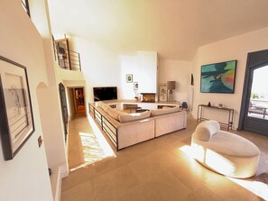 A modern living room with a sofa, a TV, a lamp, and artwork on the walls. - 550-square-meter vacation rental home in Mougins (Mougins)