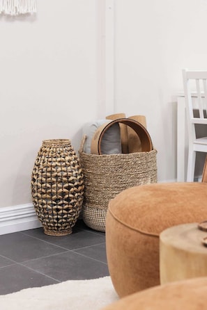 A room with a woven basket, a tall vase, and a chair.