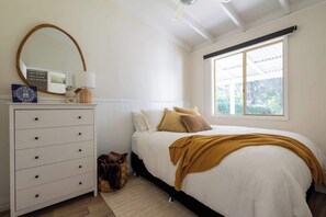 A bedroom with a bed, dresser, mirror, and window. - Cosy Winter Retreat  Fire, Tea & Sauna (preston beach)