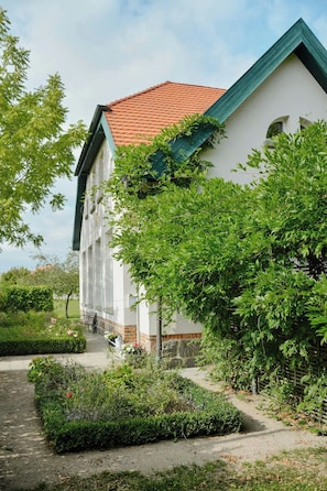 Ein Gebäude mit rotem Ziegeldach, weißen Wänden und grünen Verzierungen.