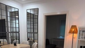 Een moderne woonkamer met een bank, stoelen, een ronde tafel en een lamp.