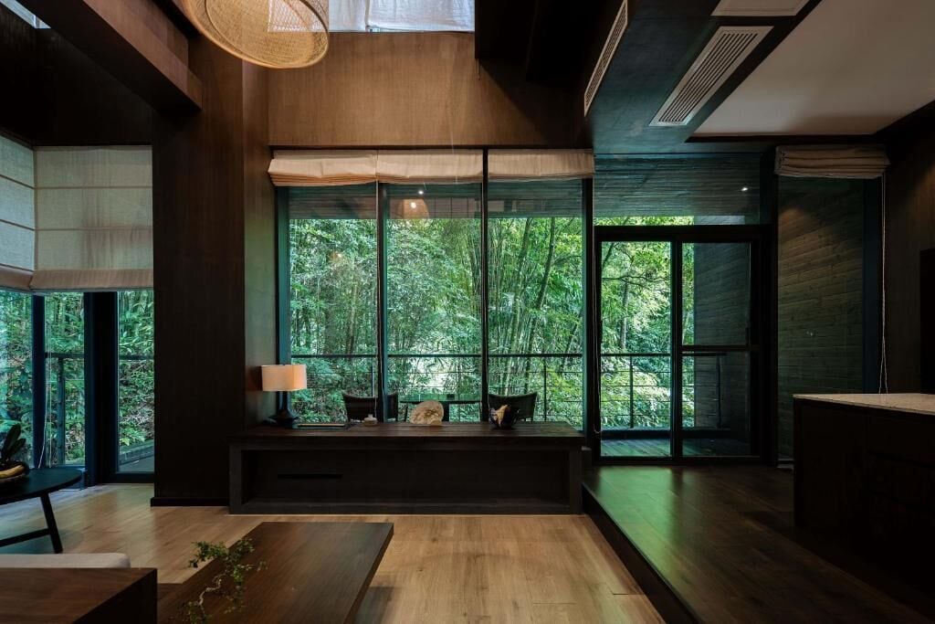 A modern interior with a large window, a bench, and a lamp.
