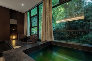 A room with a large window, a small pool, a chair, and a shelf. - zuowang hotel (Chengdu)