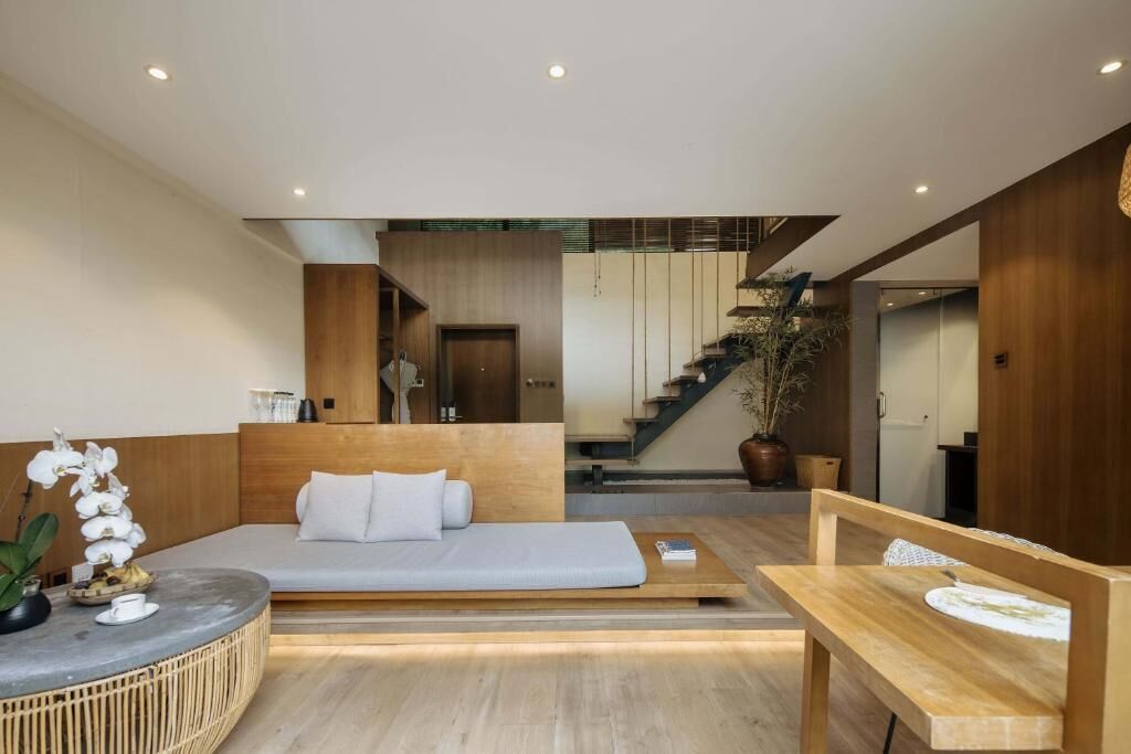 Una habitación de hotel moderna con una cama, un escritorio y una escalera que conduce a un piso superior.