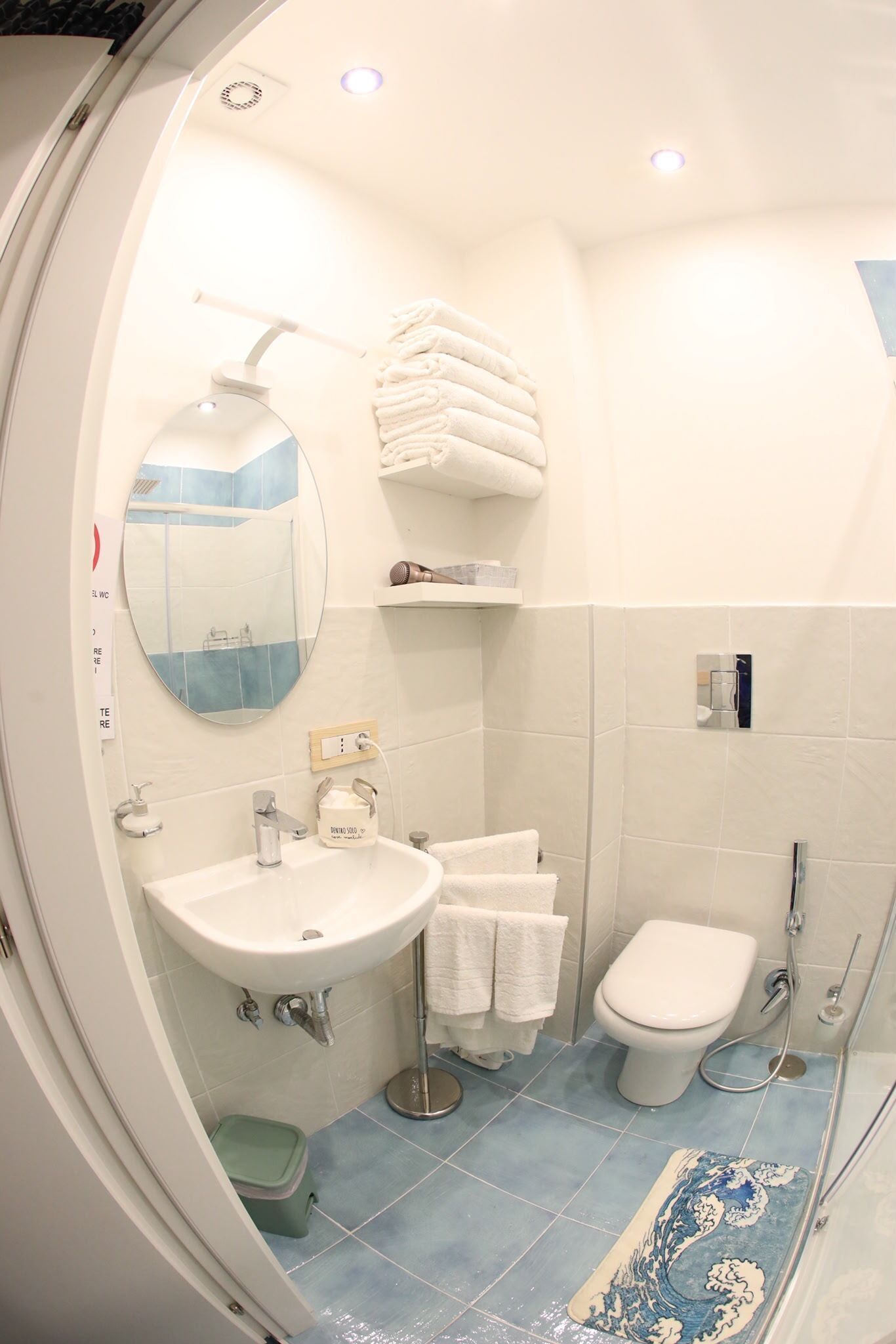Ein Badezimmer mit Waschbecken, Spiegel, Toilette und Duschbereich.
