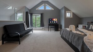 A bedroom with a bed, a desk, a chair, a TV, and a window. - Huntsville Lakeview Retreat | Jacuzzi & Games (Huntsville)
