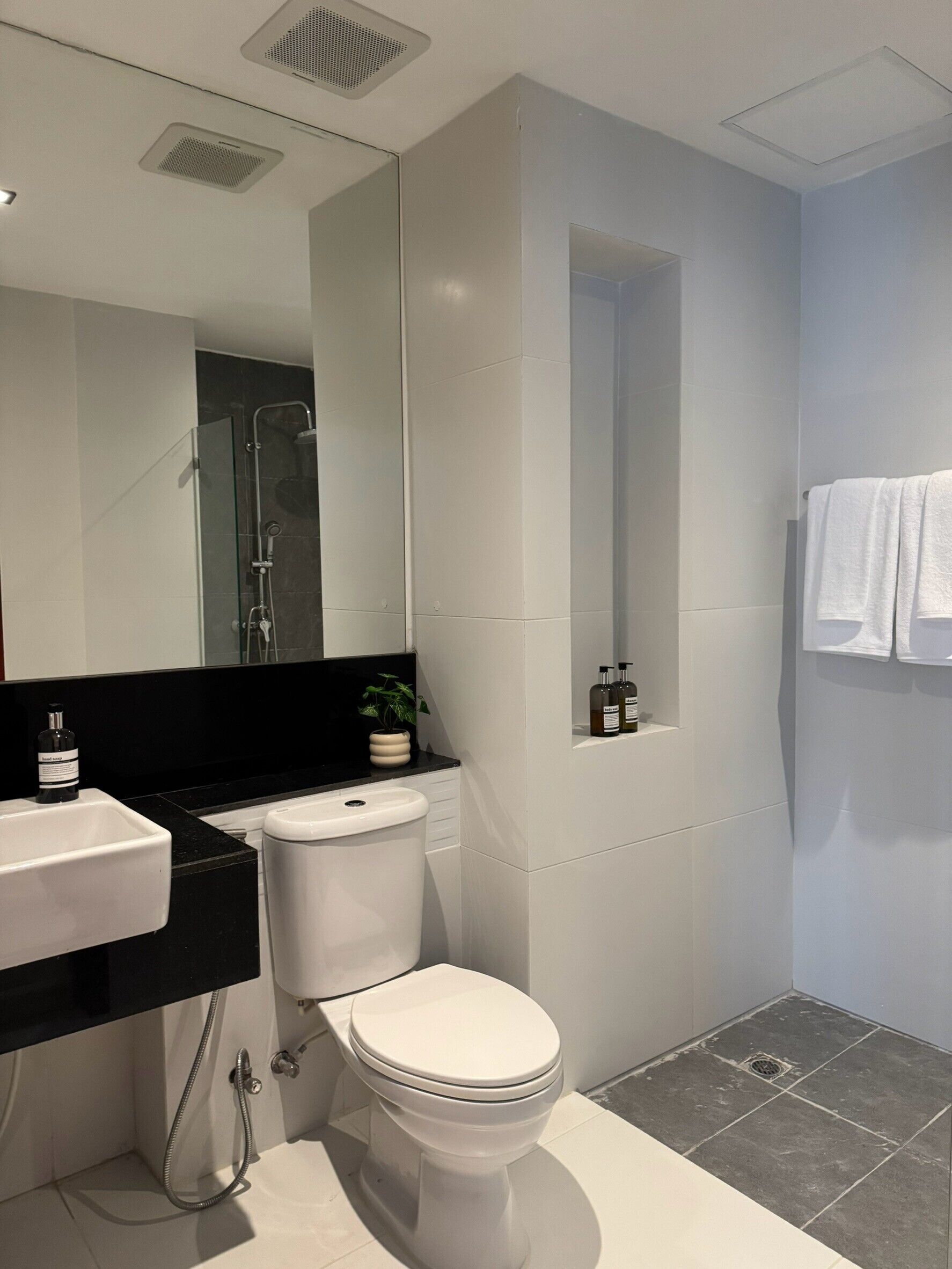 Une salle de bain moderne équipée de toilettes, d’un lavabo et d’une douche.